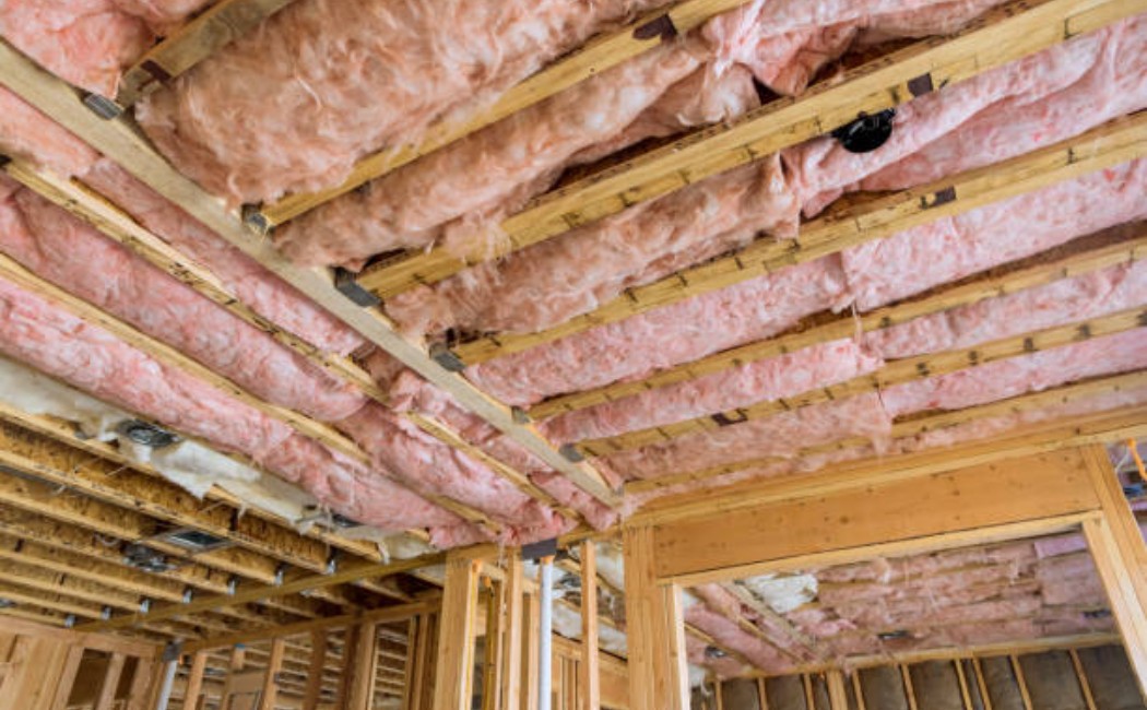 Fiberglass insulation batts placed between wooden ceiling joists in the attic.