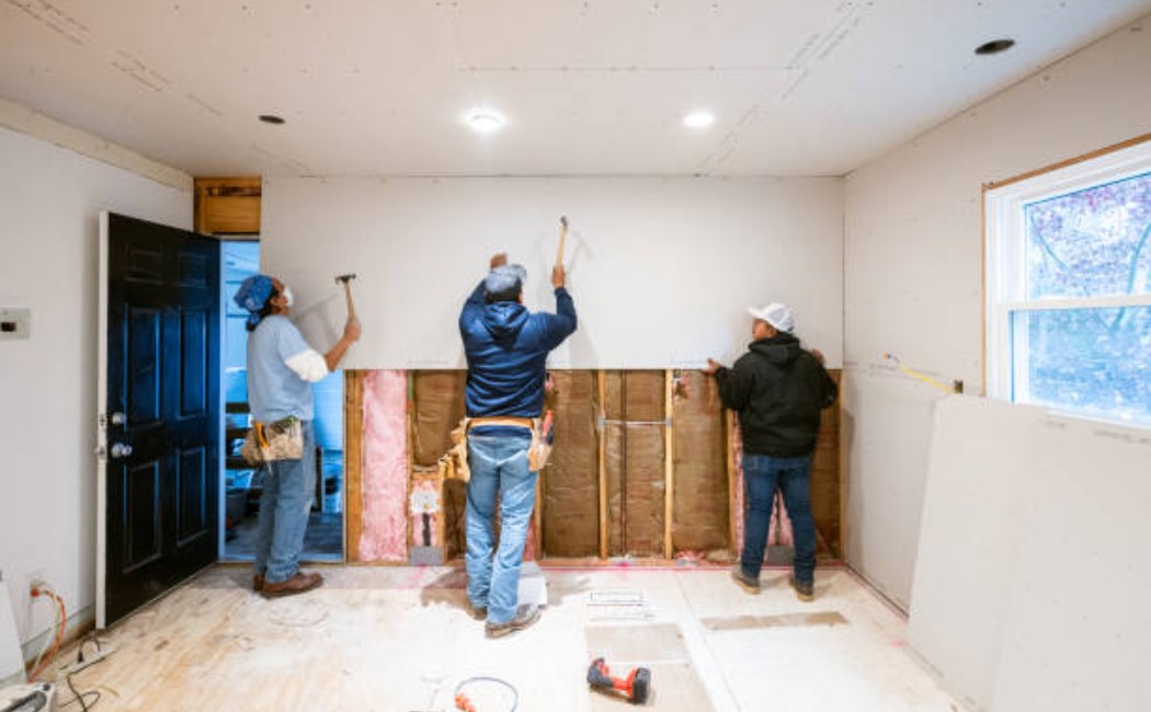 Contractors fitting drywall panels during kitchen remodeling