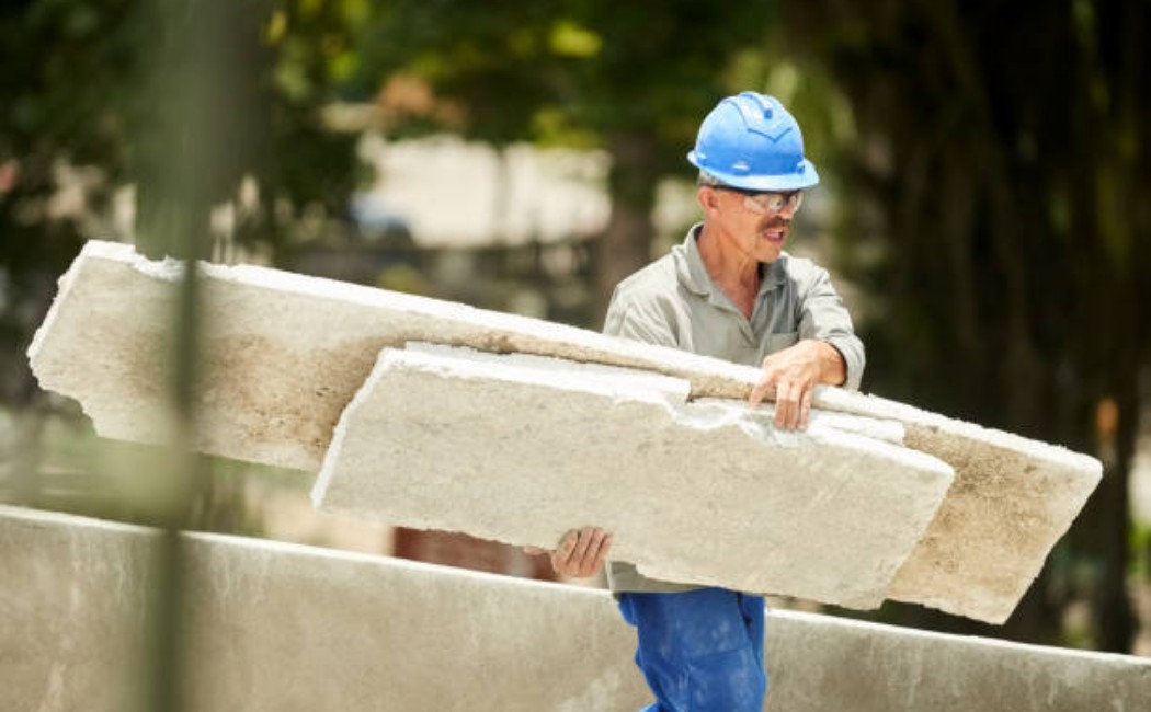 Workers removing old insulation from a house roof