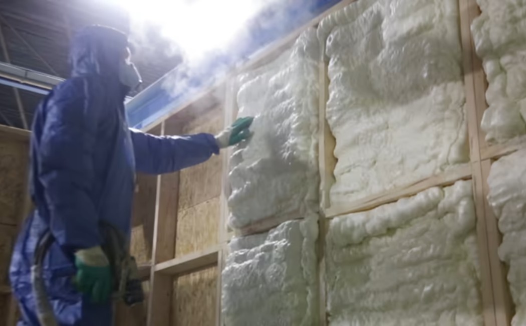 Spray foam insulation on wooden house wall Fiberglass Batts vs Spray Foam Services