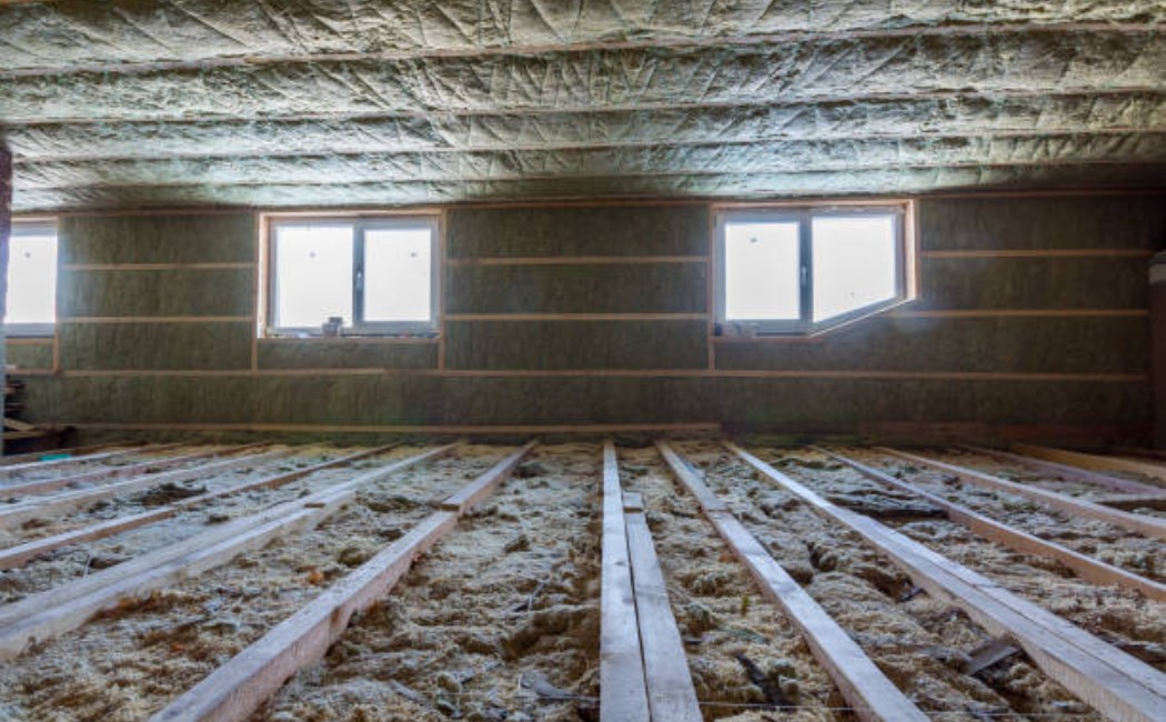 House attic insulation with fiberglass material in the roof structure.
