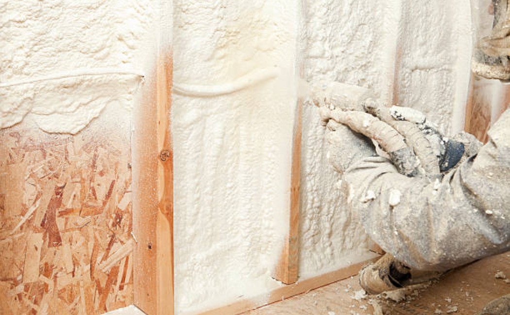 Insulating home walls with spray foam insulation.
